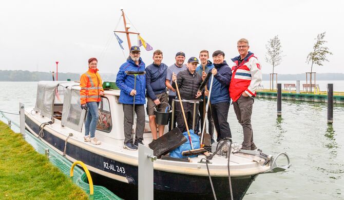 SAS unterstützt Reinigungsaktion auf der Insel mit Müllsäcken und Handschuhen.